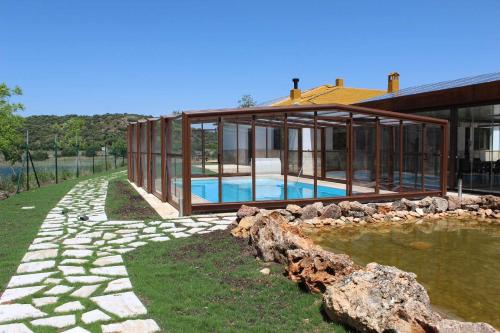 a house with a swimming pool in front of it at Casas Rurales Laguna La Tinaja in Ossa de Montiel