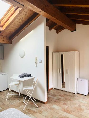 a white table and chairs in a room with a ceiling at Casa Cleopatra in Bergamo