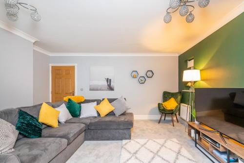 a living room with a gray couch and yellow pillows at 9 College Court Spacious, Modern 4-Bed Townhouse in York - Pass the Keys in York