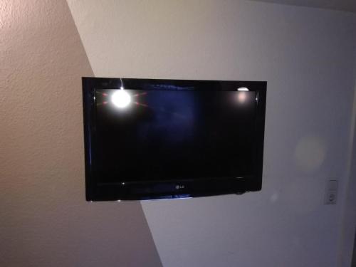 TV de pantalla plana colgada en la pared en Charmante Ferienwohnung, en Plön