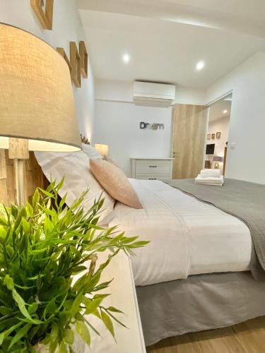 - une chambre avec un grand lit et une plante dans l'établissement Le rue Longue, à Menton