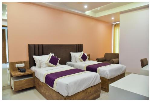 a hotel room with two beds and a couch at Hotel Siddharsh Heritage in Jaipur