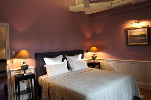 a bedroom with a bed with two lamps on both sides at La Cour Berbisey - Teritoria in Dijon