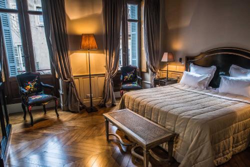 a bedroom with a large bed and two chairs at La Cour Berbisey - Teritoria in Dijon
