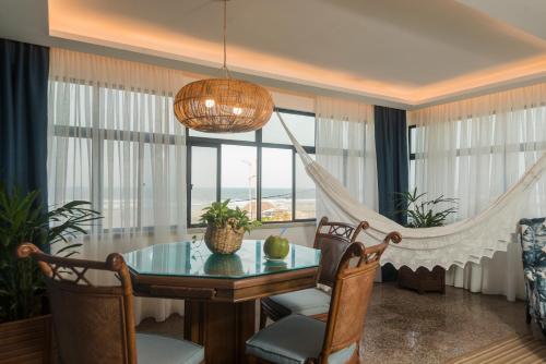 a dining room with a table and a chandelier at Janela de Sol in Fortaleza