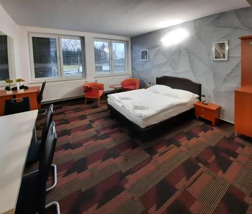 1 dormitorio con 1 cama, mesa y sillas en Relaxcentrum Mrkáček Lišov, en Lišov