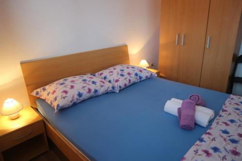 a bedroom with a blue bed with two towels on it at Apartment Lončarević in Hvar