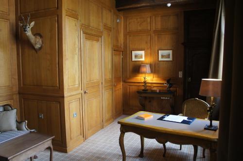 a room with a desk and a table with a deer head on the wall at La Cour Berbisey - Teritoria in Dijon