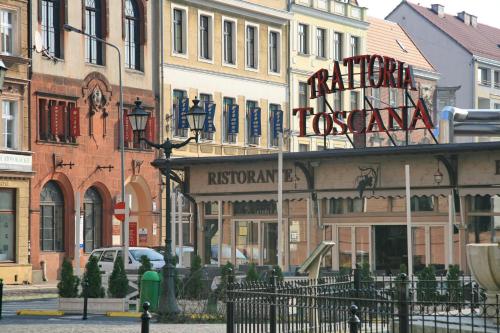 a building with a sign for a restaurant on a street at Apartamenty Starówka - Melody in Szczecin