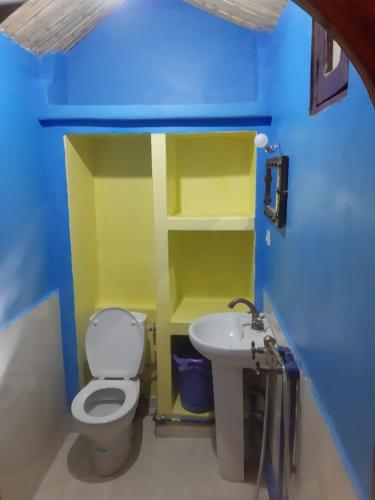 a small bathroom with a toilet and a sink at Chez Belkacem in Merzouga