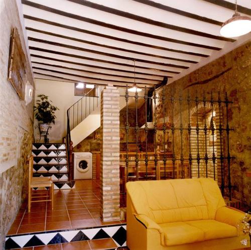 sala de estar con sofá amarillo y escalera en Casa Rural El Solan en Blanca