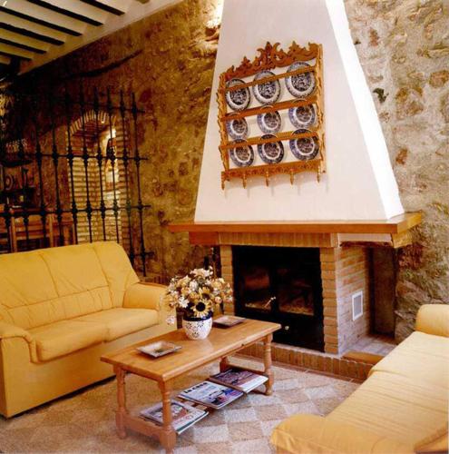 sala de estar con sofá y chimenea en Casa Rural El Solan en Blanca