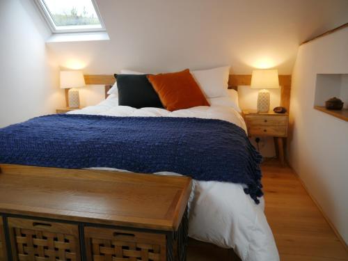 a bedroom with a bed and two lamps and a window at The Studio @ Bridge Cottage in Totnes