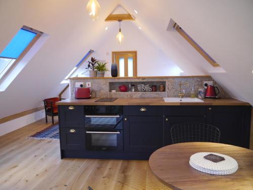 a kitchen with a stove and a sink and a table at The Studio @ Bridge Cottage in Totnes