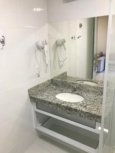 a bathroom with a sink and a mirror at Piazza Diroma com acesso Acqua Park e Splash in Caldas Novas