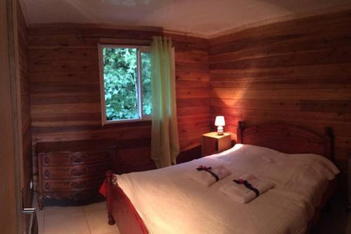 sypialnia z łóżkiem w drewnianym domku w obiekcie Ti' case la plaine w mieście La Plaine-des-Palmistes