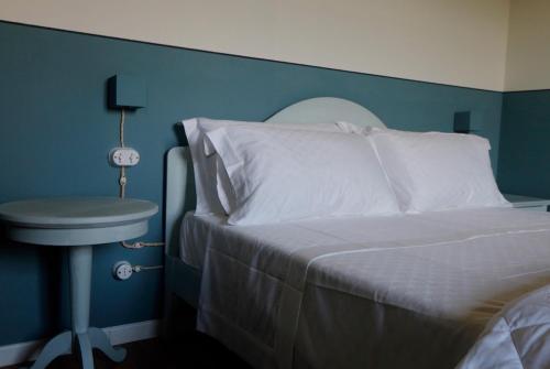a bedroom with a white bed and a blue wall at Podere La Doccia in Civitella in Val di Chiana