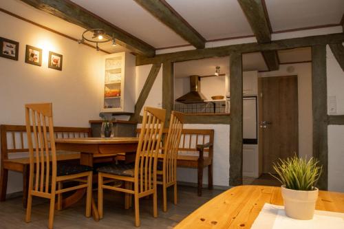 cocina y comedor con mesa de madera y sillas en Xavers Ranch, en Meschede