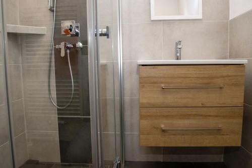 a bathroom with a shower with a wooden vanity and a sink at Xavers Ranch in Meschede