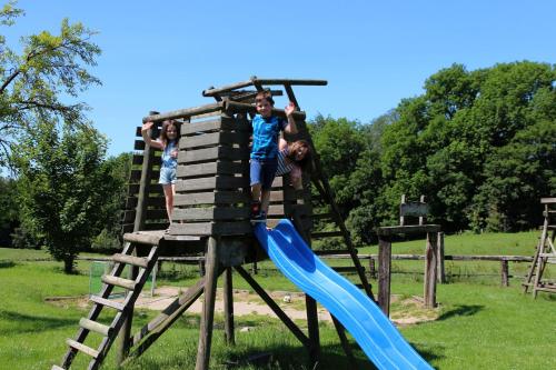 two children playing on a playground with a slide at Xavers Ranch in Meschede
