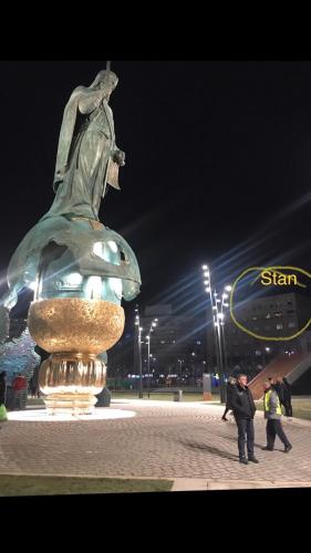 una statua di una donna seduta in cima a una fontana di Savski Square Suites a Sajmište