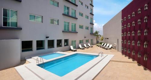a swimming pool in front of a building at HS HOTSSON Smart León Centro Max in León