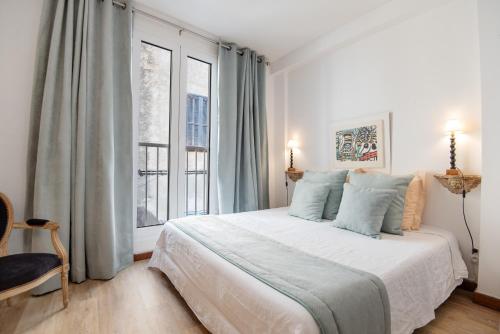 a bedroom with a bed and a large window at Le Balcon du Pêcheur in Calvi