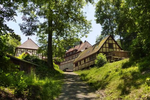 a path in front of a group of wooden buildings at Waldgasthof Wildbad in Burgbernheim