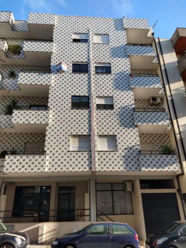 a white building with windows and a car parked in front at APART Alojamentos Para Turismo e Negocios in Braga
