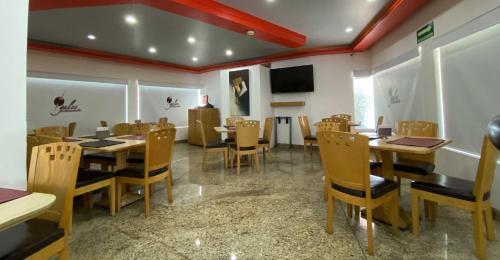 een eetkamer met tafels en stoelen en een tv bij Hotel Lord in Mexico-Stad