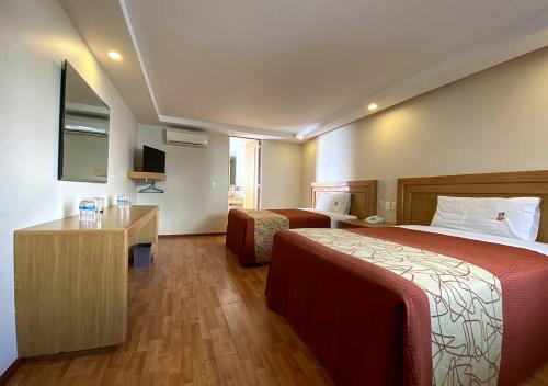 a hotel room with two beds and a television at Hotel Lord in Mexico City