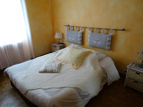 a bedroom with a large white bed with two pillows at Aqui Sian Ben in Castellane