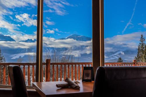 a table and chairs in front of a large window at Coast Hillcrest Hotel in Revelstoke