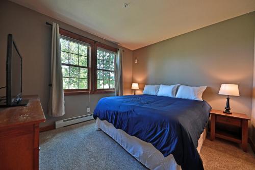 Un dormitorio con una cama azul y una ventana en Kicking Horse Lodges 3-202, en Granby