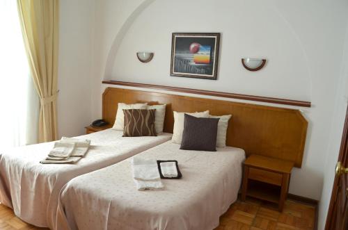 a hotel room with two beds with towels on them at Residencia Filipe in Guarda