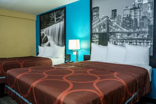 A bed or beds in a room at Super 8 by Wyndham Wichita Airport West Kellogg