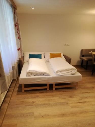 a bed with two pillows on it in a room at Haus Partoll in Kappl
