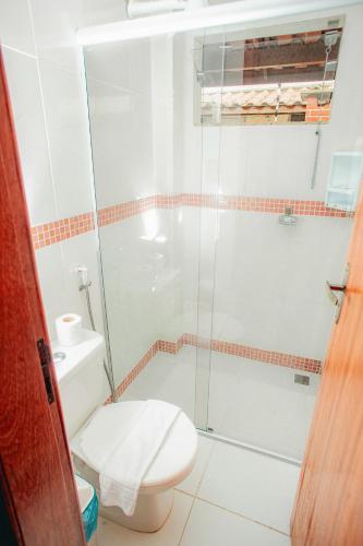 a bathroom with a toilet and a glass shower at Apartamento para família - Duplex Mont Moriá in Porto Seguro