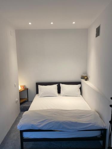 a bedroom with a bed with white sheets and pillows at Garden Apartament Petrila in Petrila