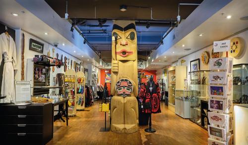 a store with a large totem pole in the middle at Skwachàys Lodge in Vancouver