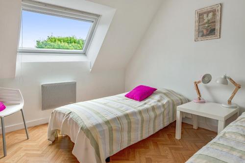 ein Schlafzimmer mit einem Bett mit einem lila Kissen darauf in der Unterkunft Maison de 2 chambres a Guimaec a 500 m de la plage avec vue sur la mer jardin amenage et wifi in Guimaëc