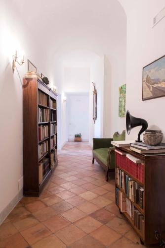 a living room with a book shelf filled with books at Palazzo Suriano Heritage Hotel in Vietri sul Mare