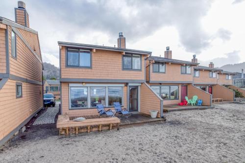 a house with two blue chairs on a patio at Breakers Beach House 4 - Meredith Lodging in Neskowin