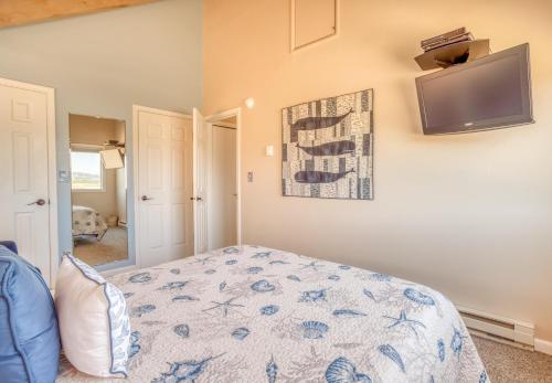 a bedroom with a bed and a tv on the wall at Breakers Beach House 9 - Meredith Lodging in Neskowin