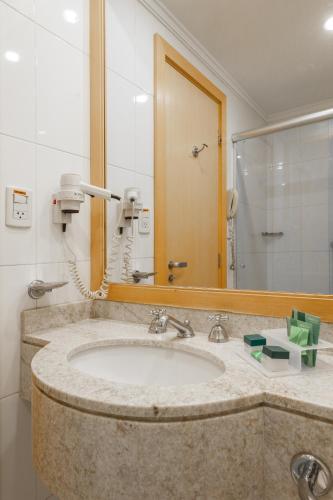 a bathroom with a sink and a mirror at Slaviero Guarulhos Aeroporto in Guarulhos