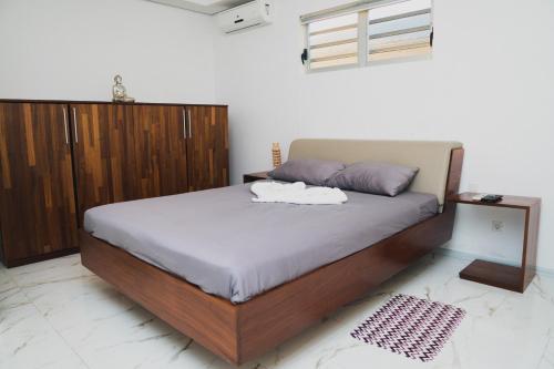 a bedroom with a large bed with a wooden cabinet at Liberdada Villa SURINAME in Wanica