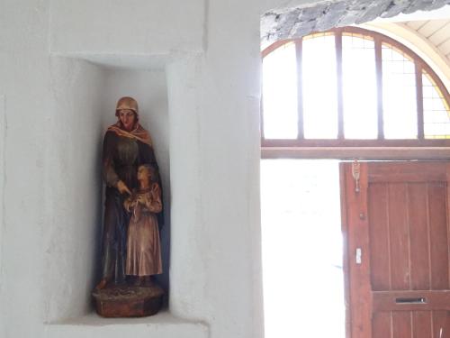 a statue of a virgin and child on a wall next to a window at SintAnna B&B PetitHotel in Yerseke