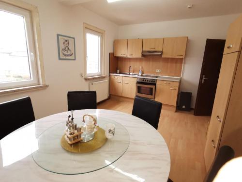 a dining room with a table and a kitchen at Pension Xiang-Ming in Lohr am Main