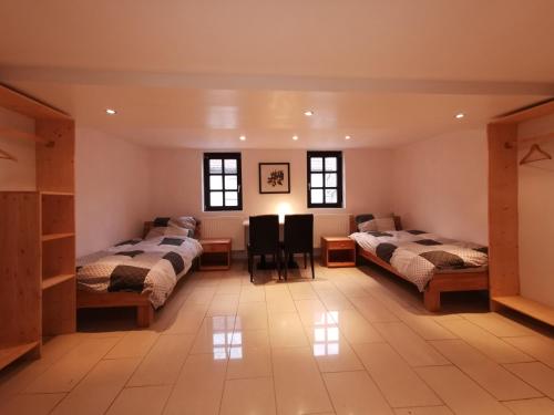 a room with three beds and a table and chairs at Pension Xiang-Ming in Lohr am Main