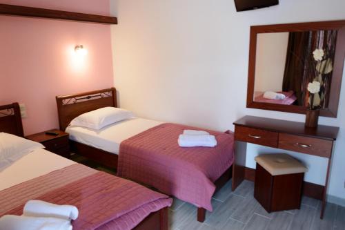 a hotel room with two beds and a mirror at Vila Aleka in Nei Poroi